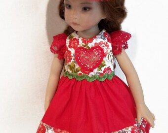 May include: A doll wearing a red dress with a floral bodice and a matching hat. The dress features a heart-shaped applique and a green trim. The hat is adorned with a large red flower and a small ladybug.