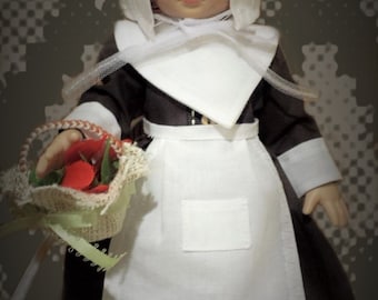 May include: A doll wearing a brown dress with a white apron and a white bonnet. The doll is holding a basket of red flowers.