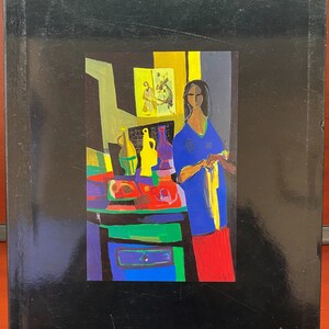 May include: A colorful painting of a woman standing in a room with a table and various objects. The woman is wearing a blue shirt and red pants. The painting is signed "M. Mouly".