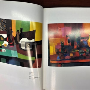 May include: Two abstract still life paintings with a cubist style. The first painting features a table with a green tablecloth, a bowl of fruit, a bottle of wine, and a guitar. The second painting features a table with a red tablecloth, a bottle of wine, and a glass of wine.