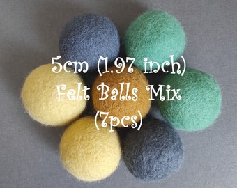 May include: Seven felt balls in a mix of yellow, green, and blue colors. The balls are 5 cm (1.97 inches) in diameter. The text "Felt Balls Mix (7pcs)" is written on the image.