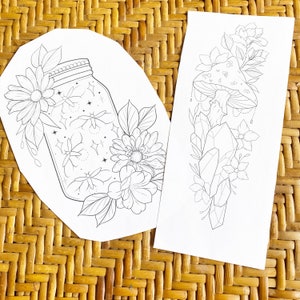 May include: Two black and white line art tattoo designs. The first design features a jar with fireflies and flowers. The second design features a mushroom with crystals and flowers.