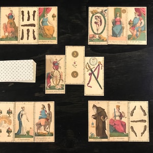 May include: A set of 10 tarot cards with colorful illustrations and text in Italian. The cards feature images of a wheel, a sword, a crown, a cup, a wand, a chariot, a star, a moon, a sun, and a world.