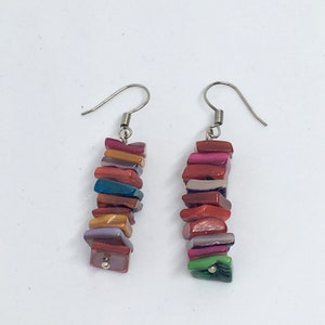 May include: A pair of dangle earrings featuring a stack of colourful, rectangular, iridescent beads. The beads are in shades of red, orange, yellow, green, blue, purple, and pink.