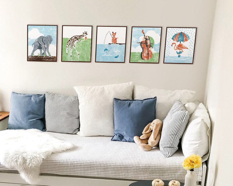 An example of 5 colorful whimsical animal art prints displayed in thin brown frames hanging on a wall