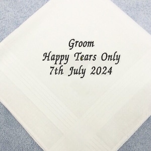 May include: White linen handkerchief with the embroidered text "Groom Happy Tears Only 7th July 2024".