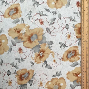 May include: White fabric with a floral pattern featuring beige and gray flowers. The fabric has a subtle texture and a repeating pattern.