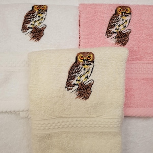 May include: Three embroidered hand towels featuring an owl design. One towel is white, one is pink, and one is cream.
