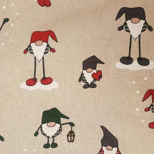 Puede incluir: Una tela beige con un patrón repetido de gnomos. Los gnomos llevan sombreros rojos, verdes y negros y tienen barbas blancas. Algunos gnomos sostienen corazones, linternas y otros objetos.