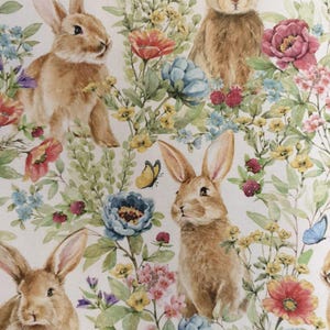 May include: A white background with a repeating pattern of brown rabbits and colorful flowers. The rabbits are in various poses, some looking at the viewer, some looking away. The flowers are in bloom and include pink, red, blue, and yellow flowers.