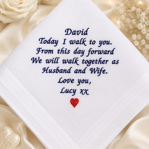 May include: A white square handkerchief featuring dark blue embroidered text that reads: David, Today I walk to you. From this day forward We will walk together as Husband and Wife. Love you, Lucy xx. A small red heart is embroidered below the text.