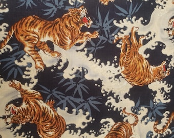 May include: A dark blue fabric with a repeating pattern of white stylized waves and orange tigers. The tigers are depicted in various poses, some leaping, some swimming, and some roaring.