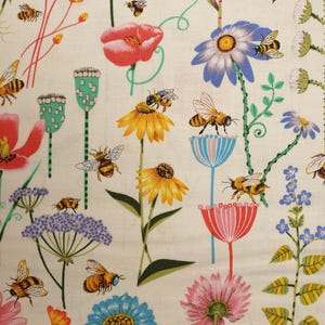 Puede incluir: Patrón de tela con flores coloridas y abejas. El diseño incluye amapolas rojas, girasoles amarillos, margaritas azules y flores rosas, con tallos y hojas verdes. Las abejas están representadas en un estilo de dibujos animados, añadiendo un toque caprichoso.