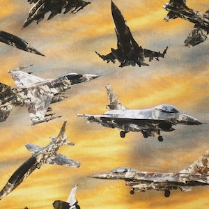 May include: A camouflage fabric with a pattern of fighter jets flying in a cloudy sky. The jets are in various shades of gray and green, with some having a more distinct camouflage pattern.