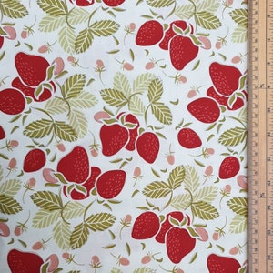 May include: White fabric featuring a repeating pattern of red strawberries, green and beige leaves, and small pink blossoms. The strawberries have seed details and the leaves have a detailed vein pattern. A ruler is visible on the right side.
