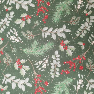 Könnte beinhalten: Dunkelgrüner Stoff mit einem sich wiederholenden Weihnachtsmuster. Das Design umfasst Stechpalmenzweige mit roten Beeren, weißen Beeren und immergrünen Zweigen. Kleine weiße Punkte sind über das Design verstreut.