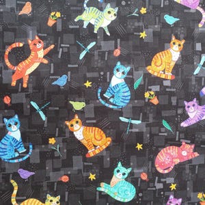 May include: Black fabric with a repeating pattern of colourful cats, birds, and dragonflies. The cats are in various poses and have different coloured stripes. The birds are blue and yellow. The dragonflies are blue and green.