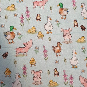 Peut inclure: Un tissu bleu clair avec un motif répété d'animaux de la ferme et de fleurs. Le motif comprend des canards, des canetons, des cochons et diverses fleurs dans des tons de rose, jaune, marron et blanc. Idéal pour les projets de couture.