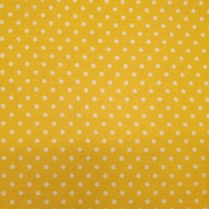 May include: Yellow fabric with a white polka dot pattern.