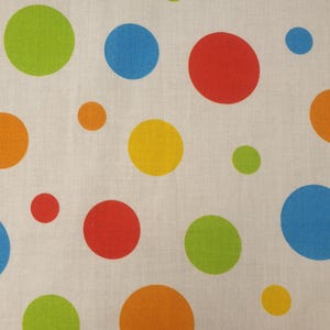 Könnte beinhalten: Ein weißer Stoff mit einem sich wiederholenden Muster aus bunten Punkten in den Farben leuchtendes Rot, Limettengrün, Himmelblau, Orange und Gelb. Die kreisförmigen Formen variieren in der Größe und sind über die Textiloberfläche verteilt.