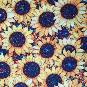 May include: A fabric featuring a repeating pattern of sunflowers. The sunflowers have yellow petals and dark blue centres. The background is a mix of blue, green, and orange.