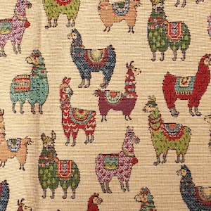 May include: A woven fabric featuring a repeating pattern of llamas in various colors including red, green, blue, pink, and orange. Each llama is depicted with a decorative saddle blanket on its back, set against a light beige textured background.