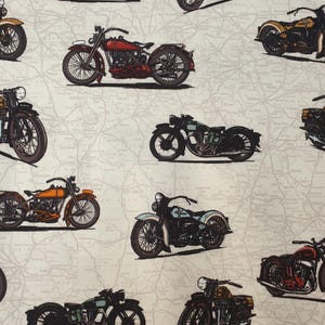 May include: A fabric print featuring a repeating pattern of vintage motorcycles in various colours including red, orange, blue, and black. The motorcycles are illustrated against a light beige background that displays a faint, detailed map design.