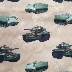 Puede incluir: Una tela beige con un patrón repetido de tanques militares verdes. Los tanques están en varias posiciones, algunos mirando hacia adelante y otros de lado. La tela tiene una textura sutil.