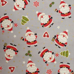 May include: Grey fabric featuring a repeating pattern of Santa Claus figures in red suits and hats, with white beards. The design includes Christmas trees, stars, hearts, and holly sprigs. Gold glitter accents the background.