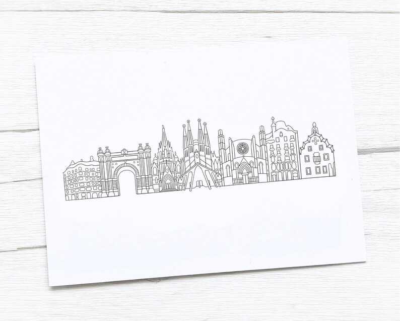 May include: A black and white line drawing of the Barcelona skyline, featuring iconic landmarks such as the Sagrada Familia and Arc de Triomf. The artwork is on a white rectangular paper, perfect for framing or gifting.