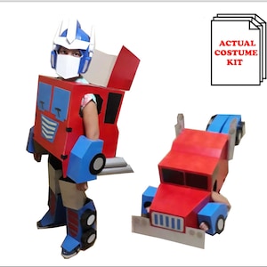 May include: A cardboard costume kit for a child to dress up as a red and blue robot. The kit includes a truck-shaped torso, blue legs, and a blue helmet. The text "ACTUAL COSTUME KIT" is visible in the image.