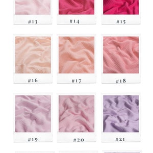 May include: A collection of 12 fabric swatches in various shades of pink, peach, purple, and grey. The fabric is a soft, textured muslin, ideal for sewing projects. The swatches are labelled with numbers 13 through 24.