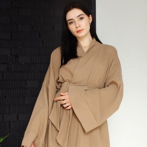 May include: A brown waffle-weave robe with long sleeves and a tie belt. The robe is made of a soft, comfortable fabric and has a relaxed fit.