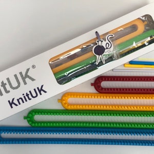 Pu&ograve; includere: Una collezione di telai per maglieria KnitUK in vari colori, tra cui blu, verde, giallo e rosso. Il set include una scatola bianca con il logo KnitUK e diversi strumenti per lavorare a maglia. I telai sono in plastica e progettati per progetti di maglieria.