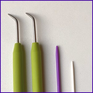 May include: Three crochet hooks, two green and one purple, and a white crochet hook. The green crochet hooks have a metal tip and a green plastic handle. The purple crochet hook has a metal tip and a purple plastic handle. The white crochet hook has a metal tip and a white plastic handle.