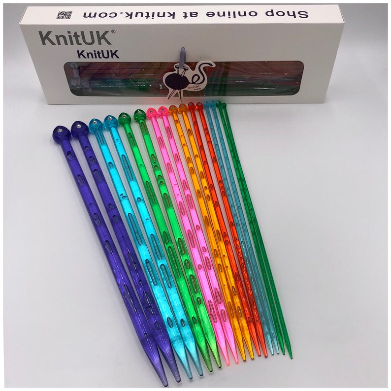 May include: A set of 16 colorful plastic knitting needles. The needles are arranged in a rainbow pattern, with each needle a different color. The needles are all the same size and have a pointed tip.