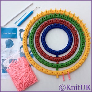 Puede incluir: Un conjunto de cinco telares circulares redondos de colores, con una bolsa de agujas de tejer rosas e instrucciones. Los telares son amarillos, verdes, rojos, azules y morados.