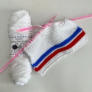 May include: White yarn with a red, blue, and white striped knitted fabric. The yarn label reads "KnitUK Cotton Rich Chunky 100g".