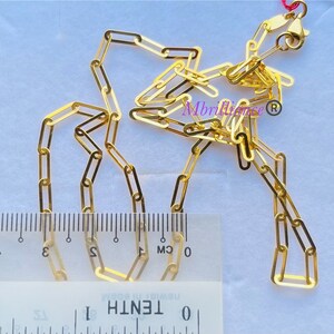 Puede incluir: Un collar de cadena de oro con cierre. La cadena est&aacute; hecha de peque&ntilde;os eslabones rectangulares. La cadena se mide con una regla, mostrando que tiene aproximadamente 3 cm de largo.