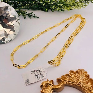 Puede incluir: Un collar de cadena de oro con una etiqueta de papel que dice "NZ 52 10.00g 886 K 18 916".