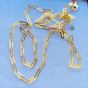 Puede incluir: Un collar de cadena de oro con un dise&ntilde;o delicado y enlazado. La cadena est&aacute; hecha de peque&ntilde;os eslabones rectangulares que est&aacute;n conectados entre s&iacute; para formar un bucle continuo. La cadena se muestra sobre un fondo blanco.