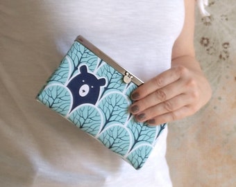 May include: A blue and white patterned purse with a black bear illustration. The purse has a silver clasp.