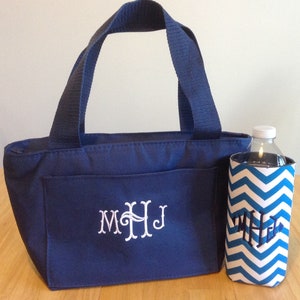 K&ouml;nnte beinhalten: Eine dunkelblaue isolierte Lunch-Tasche mit einem wei&szlig;en Monogramm "MHJ" und einem passenden blauen und wei&szlig;en Chevron-Muster-Isoliergetr&auml;nkehalter.