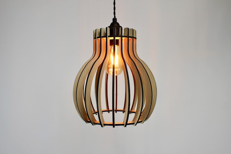 May include: A wooden pendant light fixture with a bulbous shape and a black metal frame. The light is on and the bulb is glowing.