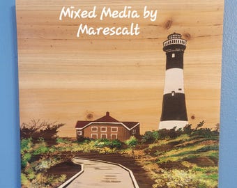 May include: A mixed media painting on wood depicting a lighthouse with black and white stripes, a small house with red roof, and a path leading to the lighthouse. The painting is titled "Mixed Media by Marescalt".