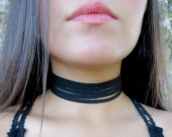 May include: A black choker necklace with multiple layers of fabric.