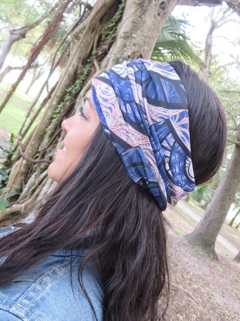 May include: A woman with long dark hair is wearing a blue and pink patterned headband. The headband is tied in a knot at the top of her head.