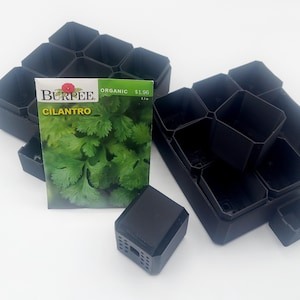 May include: Black plastic seed starting trays with individual cells, alongside a packet of Burpee organic cilantro seeds. The seed packet displays a vibrant image of cilantro leaves. A small black square object is also present.
