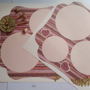 May include: A scrapbook page with a decorative border and three circular cutouts for photos. The page has a pink and brown striped pattern with hearts and floral accents.