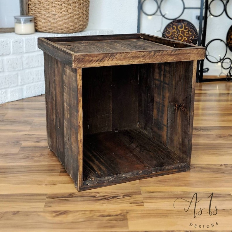 Peut inclure: Un cube de rangement en bois brun fonc&eacute; avec un dessus qui peut servir de table. Le cube a un aspect rustique en bois de r&eacute;cup&eacute;ration.